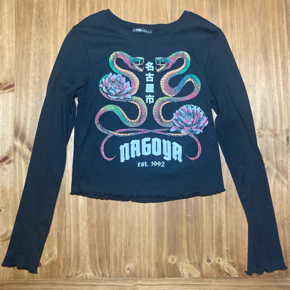 Black long sleeve top with ruffle detailing and colorful snake design